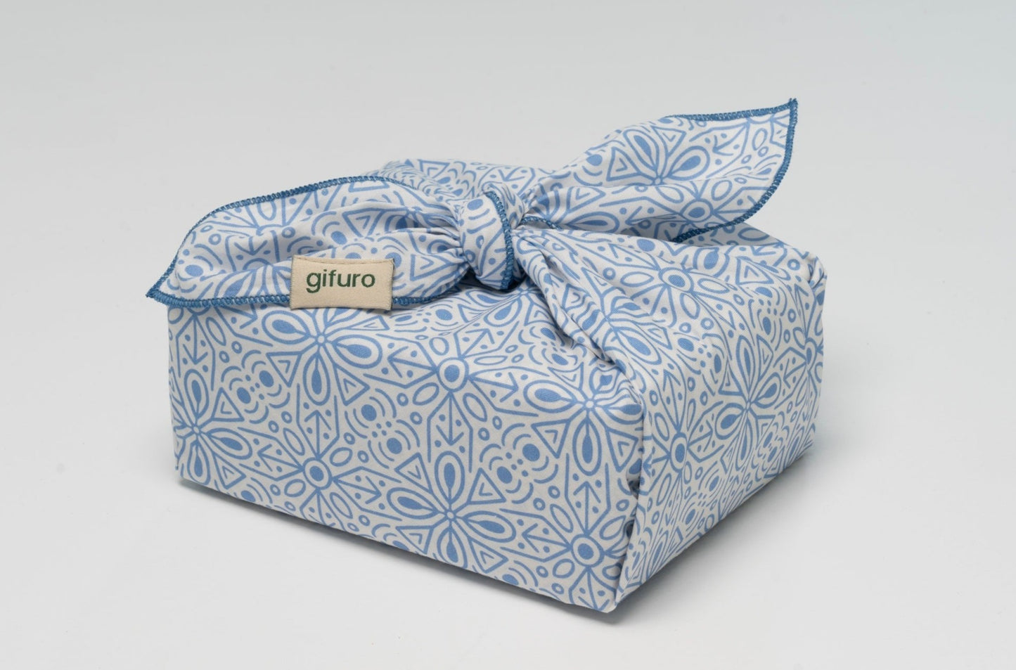 Geschenk verpackt mit dem Geschenktuch Azura in Blau und Weiß im Furoshiki-Stil