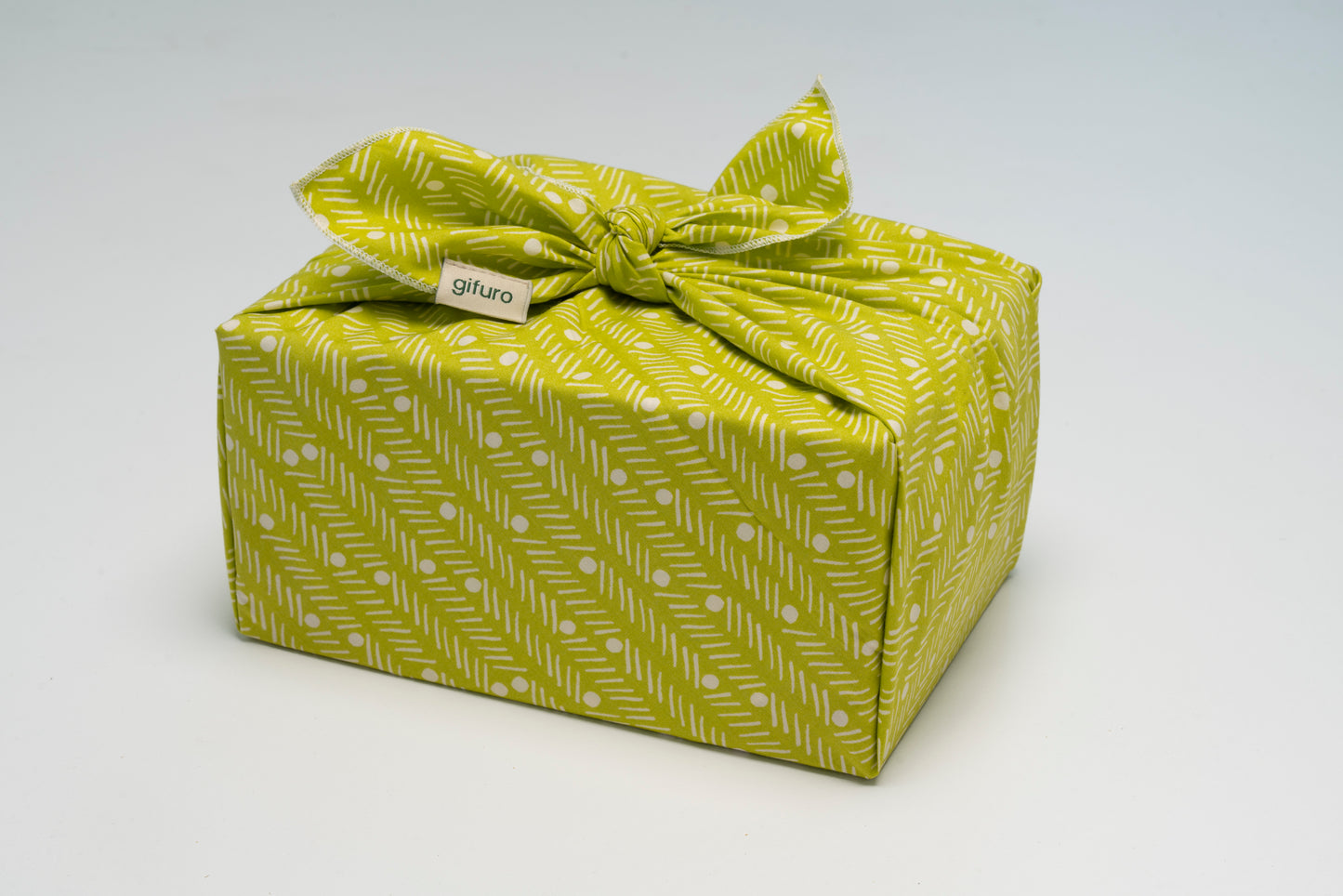 Geschenk verpackt mit Geschenktuch Legolas – grün mit weißem Muster im Furoshiki-Stil
