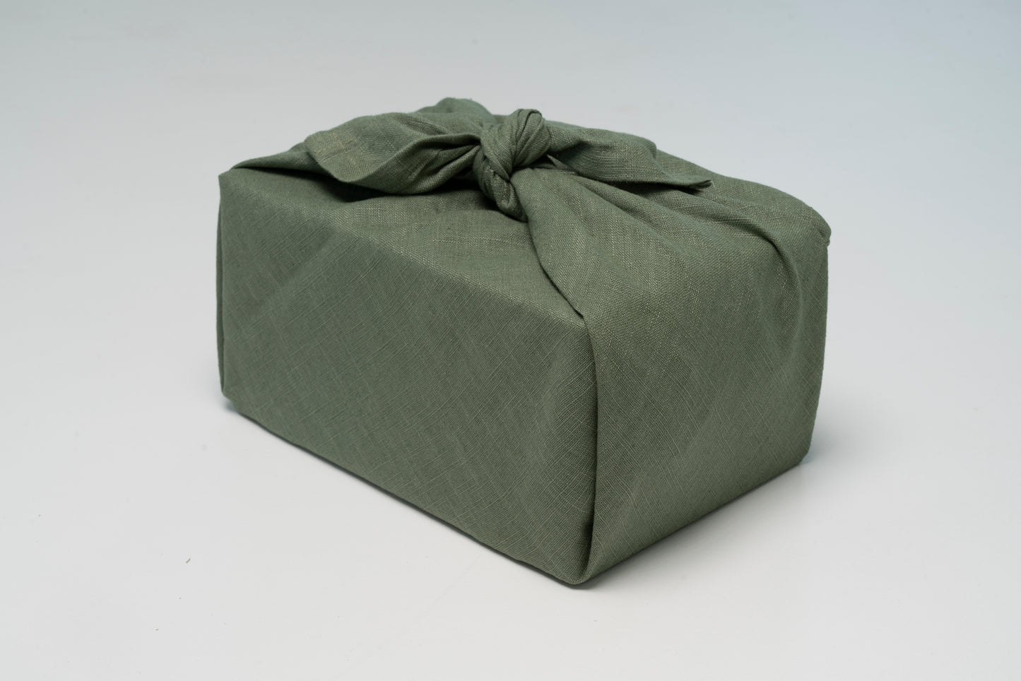 Geschenk verpackt mit Leinen Geschenktuch in Grün – hochwertig und wiederverwendbar