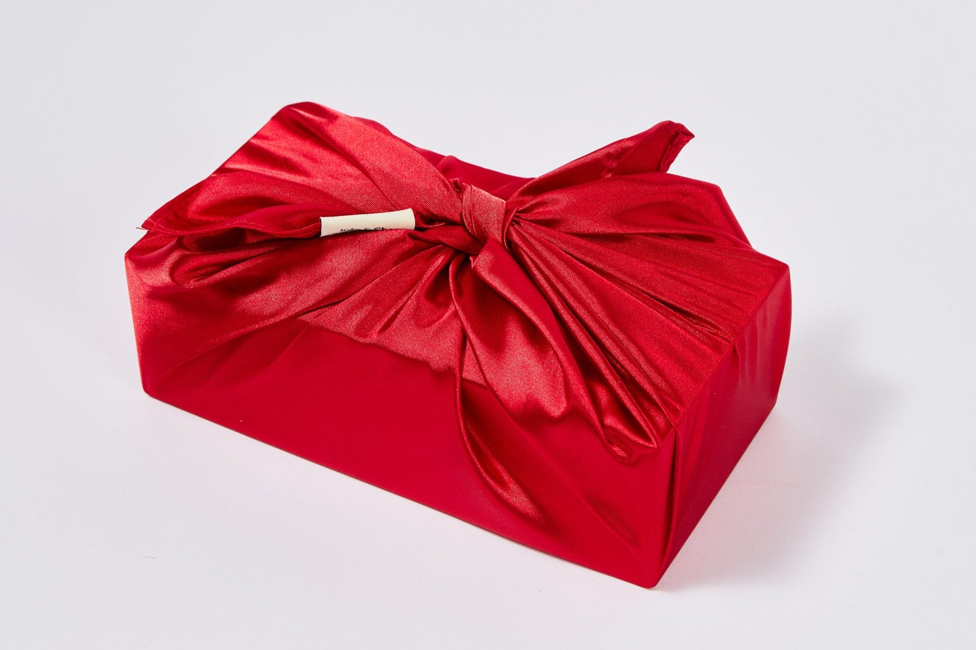 Geschenk verpackt mit dem Geschenktuch Clara in tiefem Rot im Furoshiki-Stil