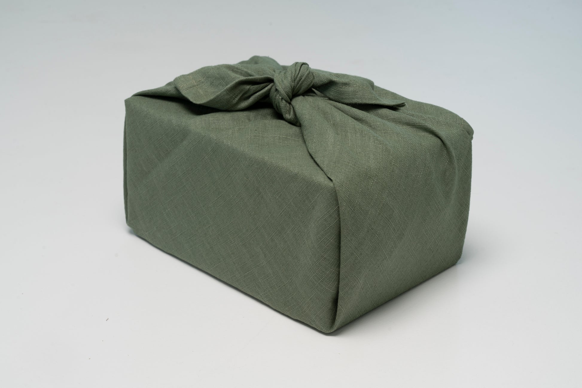 Geschenk verpackt mit Leinen Geschenktuch in Grün – hochwertig und wiederverwendbar